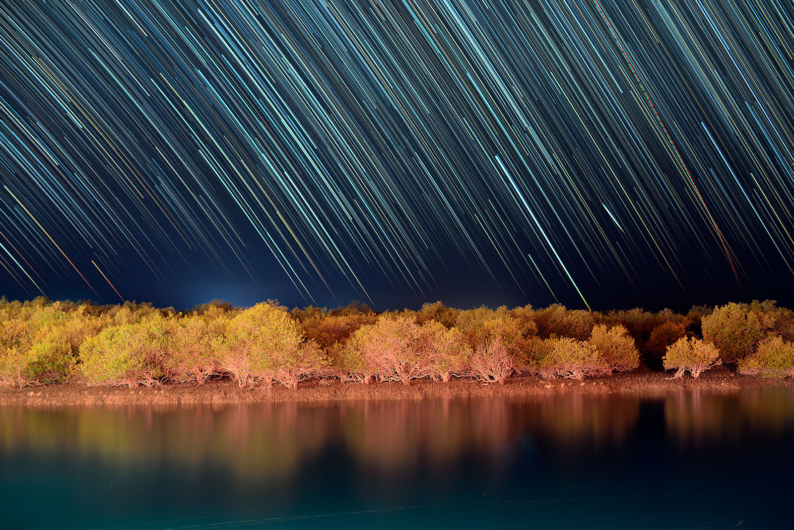 Star trails above mangrove forest which grows at the northern part of Persian Gulf. 700 individual images consequently captured through opera 50mm F1.4 FF at f/2.2 to create this shot. Kenko Red Enhancer No.1 + Cokin P123S reversely attached to the lens to control local light pollution and balancing exposure between illuminated foreground and dark sky. Each frame exposed 5 sec at ISO4000 on Nikon D610 body.